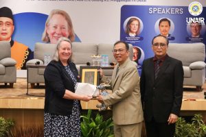 Prof Dr Muhammad Madyan SE MSi MFin, Prof (HCUA) Dr Sunarto SH MH, dan Debra Mortimer dari Federal Court of Australia pada saat sesi penyerahan cinderamata, selasa (30/9/2025). (Foto: Humas UNAIR)
