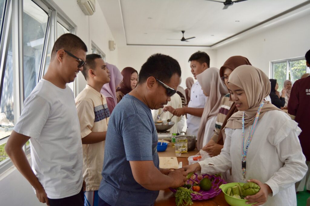 Momen kebersamaan mahasiswa Universitas Airlangga bersama peserta penyandang disabilitas saat mengikuti sesi lomba memasak. (Foto: istimewa).