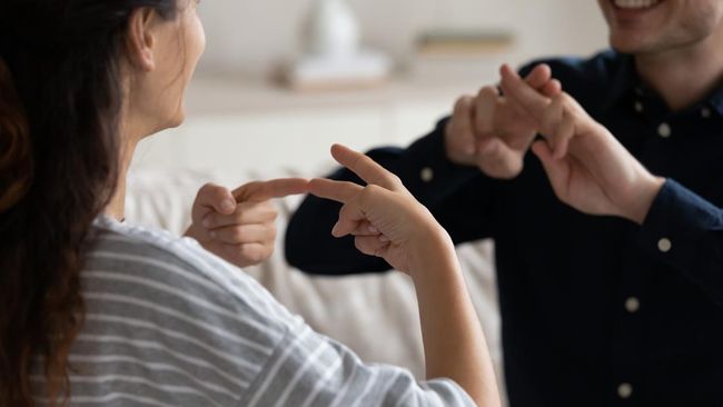 Ilustrasi dua orang sedang berkomunikasi menggunakan bahasa isyarat