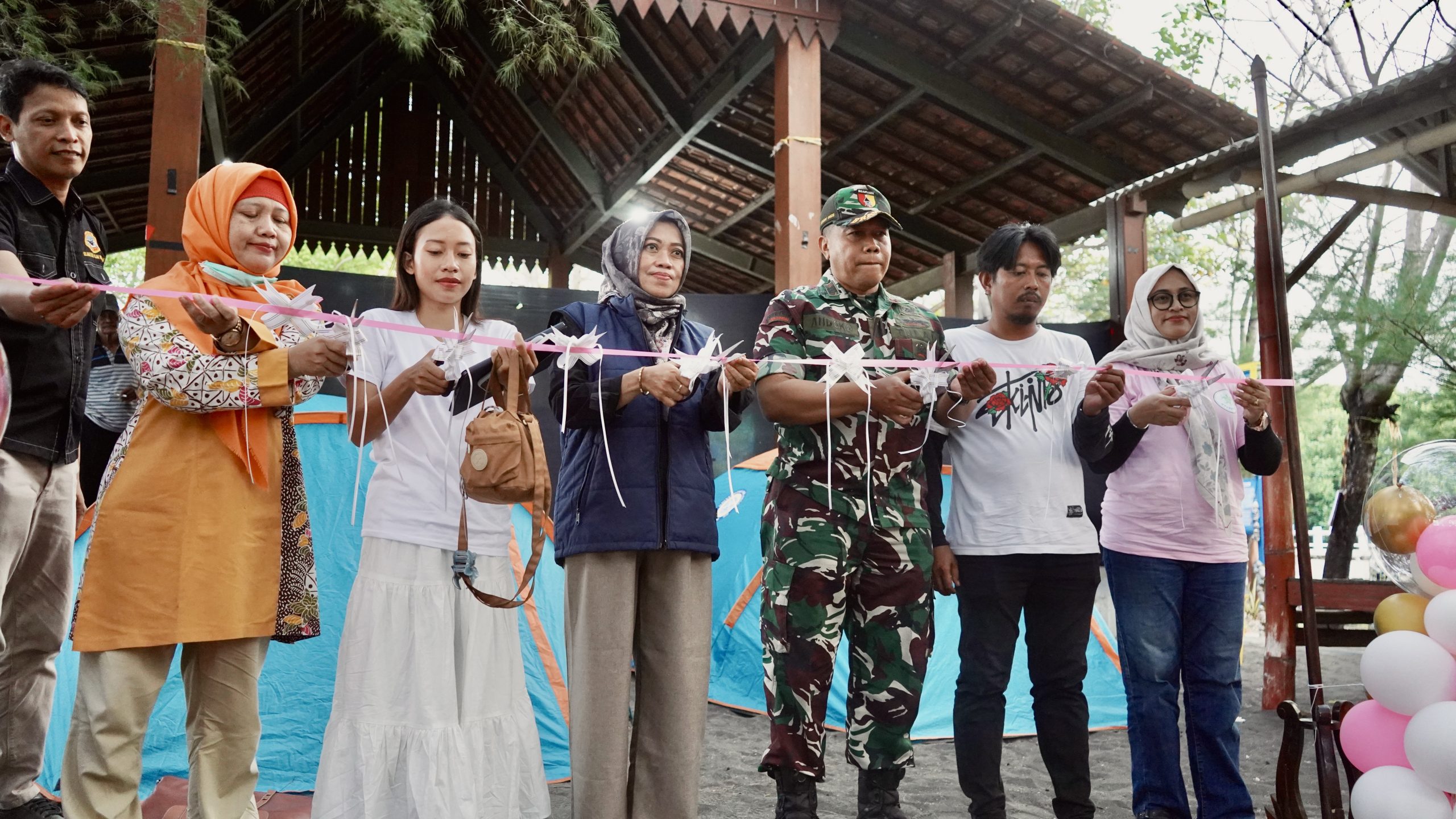 Prosesi pemotongan pita oleh perwakilan pemerintah desa, TNI, dan Ketua pelaksana sebagai tanda resmi pembukaan area camping ground Pulau Santen, Banyuwangi. (Foto: Istimewa)