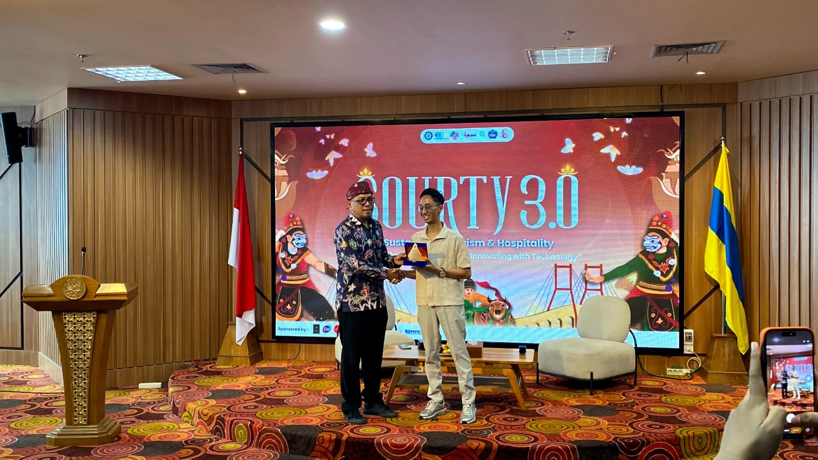 Penyerahan piagam kepada Hendra Gemma Dominant oleh perwakilan HIMA Manajemen Perhotelan (Foto : Panitia)