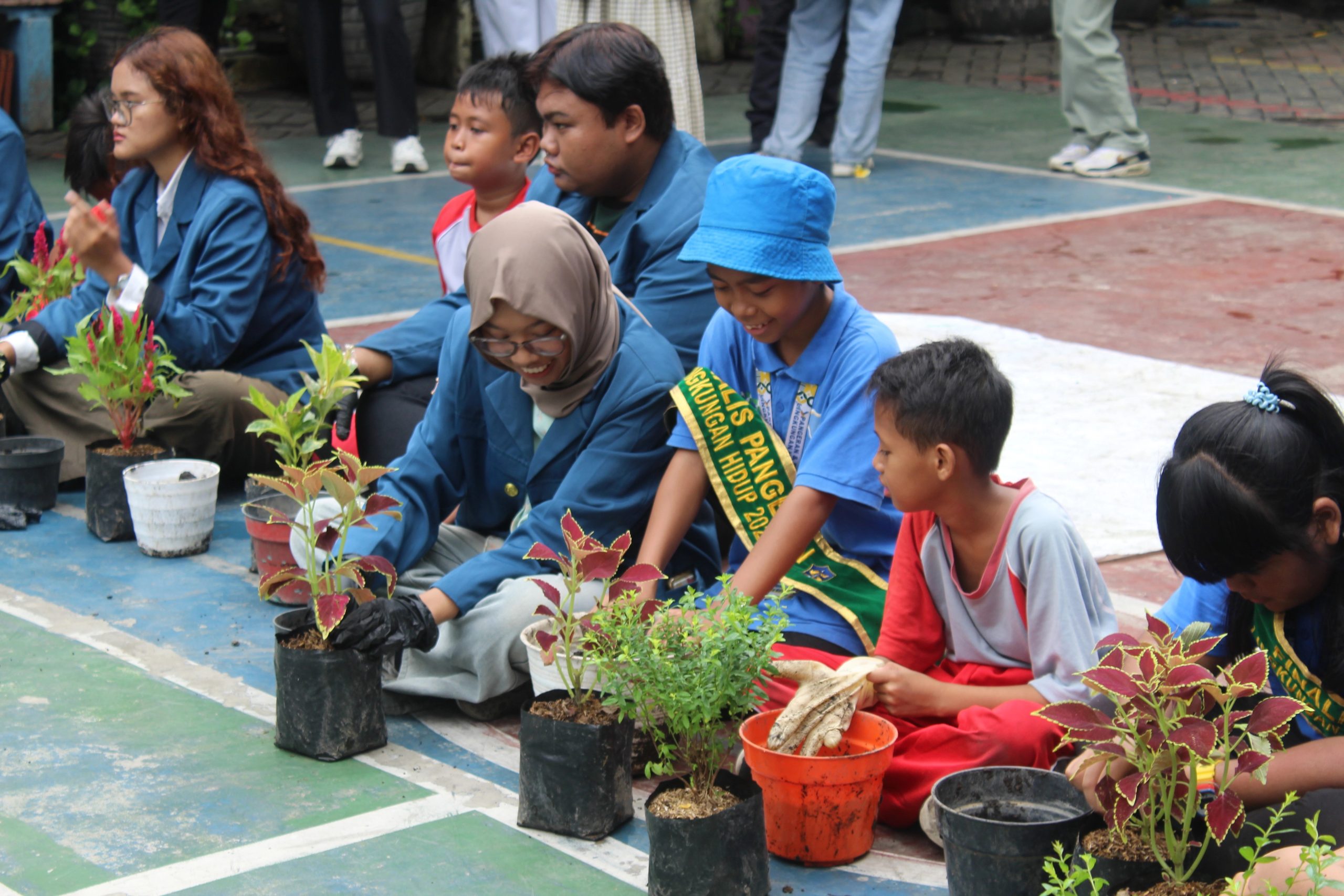 Mahasiswa BEM FEB UNAIR dan siswa SDN Kaliasin 1 melakukan sesi replanting pada puncak Ruang Abdi Vol. 3 di sekolah, Sabtu (15/11/2025). (Dok. Panitia)