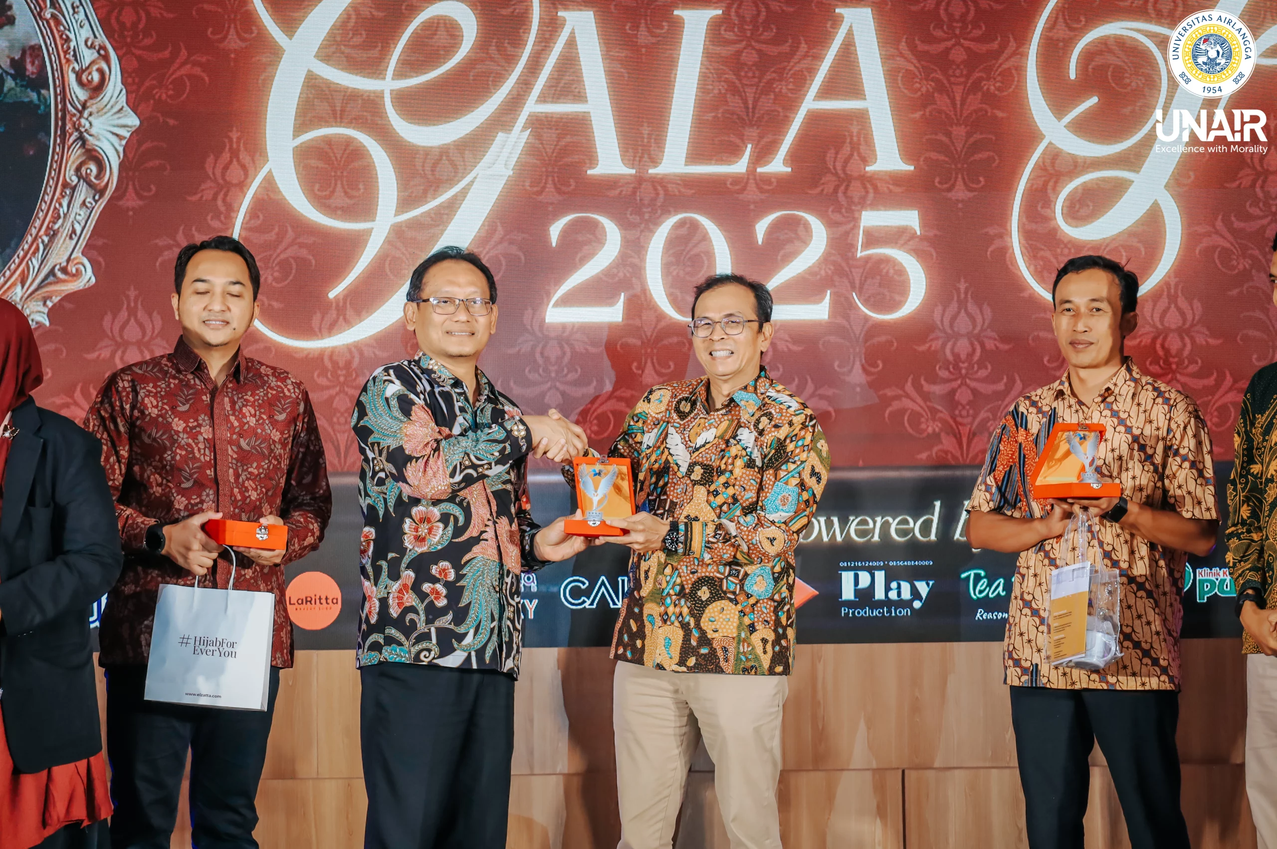 Momen Dekan FEB UNAIR Prof Dr Rudi Purwono SE MSE (kiri) saat menyerahkan plakat penghargaan "The Most Inspirational Research Lecturer" kepada Rektor UNAIR Prof Dr Muhammad Madyan SE MSi MFin di panggung GALA FEB 2025. (Foto: Humas UNAIR).
