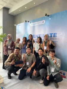 Garnis, Catherine, dan Achmad berfoto bersama juri dan peserta lain setelah kompetisi di Symposium VENTILATE 2025. (Foto: Dok. Pribadi)