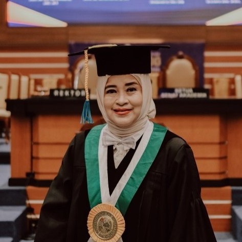 A portrait of a woman wearing academic regalia, Prof. Elly Munadziroh, a professor at the Faculty of Dental Medicine (FKG), Universitas Airlangga (UNAIR), who developed an amniotic membrane biocomposite technique