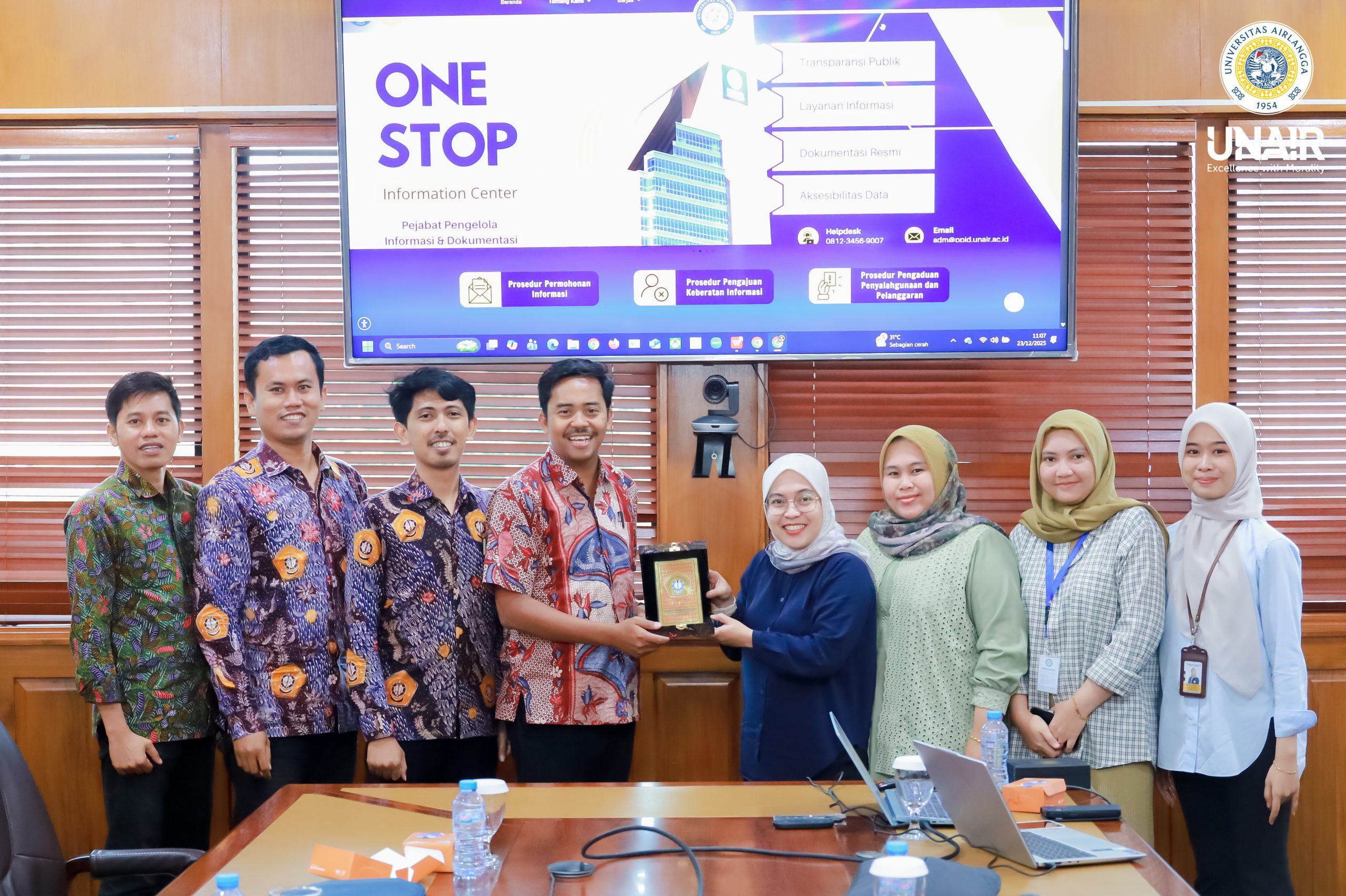 Sesi foto bersama PPID UNAIR dan PPID UTM dalam rangka kunjungan penguatan layanan informasi publik, Selasa (23/12/2025). (Foto: PHMP UNAIR)