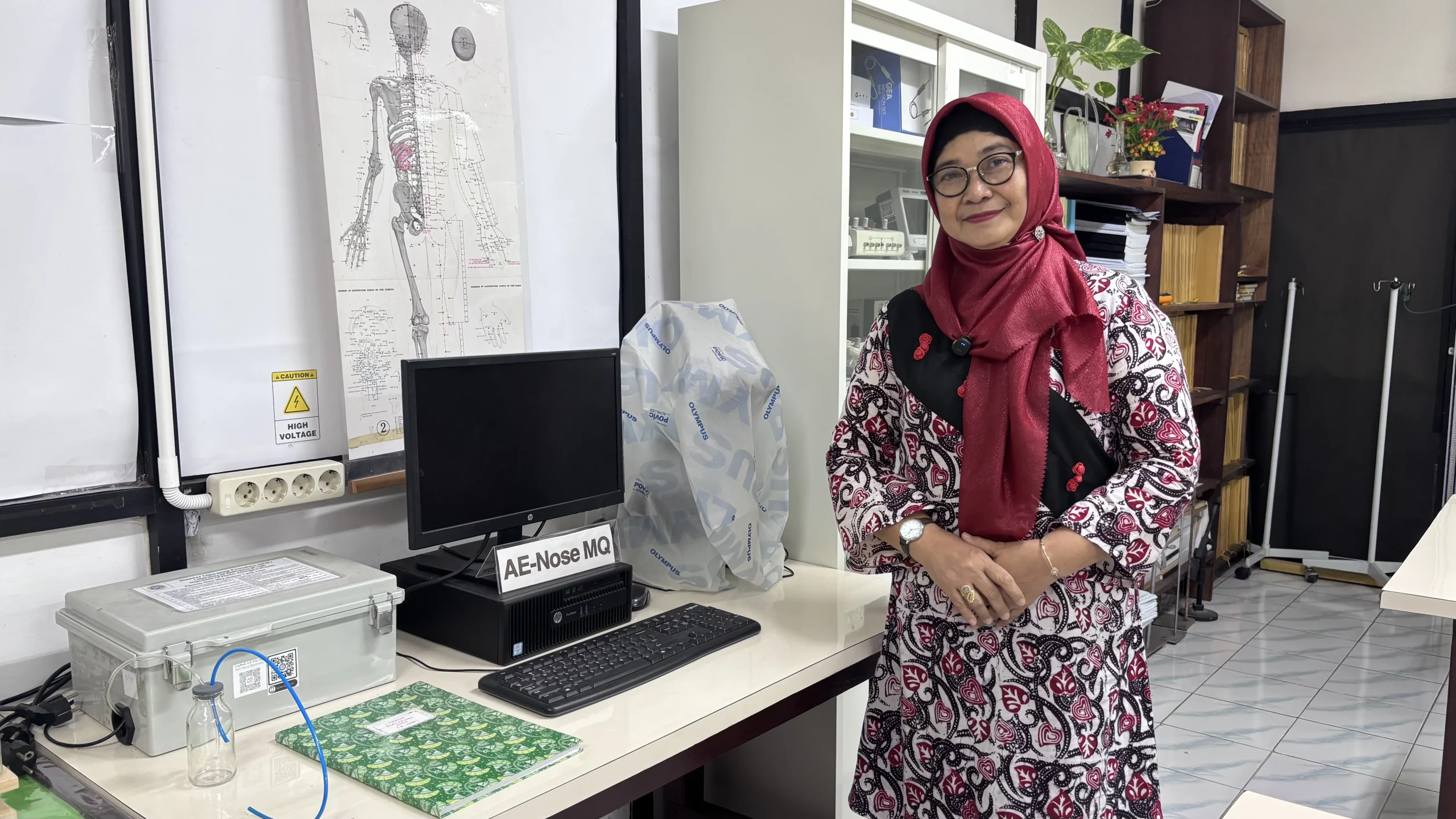 Prof. Dr. Suryani Dyah Astuti, S.Si., M.Si., Guru Besar Fakultas Sains dan Teknologi Universitas Airlangga (FST UNAIR), berpose di samping perangkat inovasi AE-Nose dengan sensor TGS yang dikembangkan untuk mendeteksi kesegaran bahan pangan. (Foto: Istimewa)