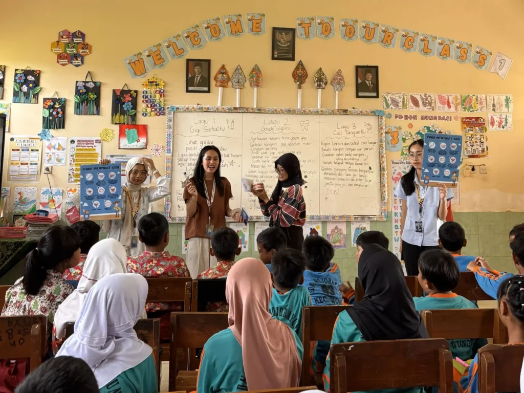 Pendampingan praktik penyikatan gigi yang benar serta pembagian sikat gigi gratis beserta bingkisan lain kepada siswa-siswa sekolah dasar SDN Mojorayung 03