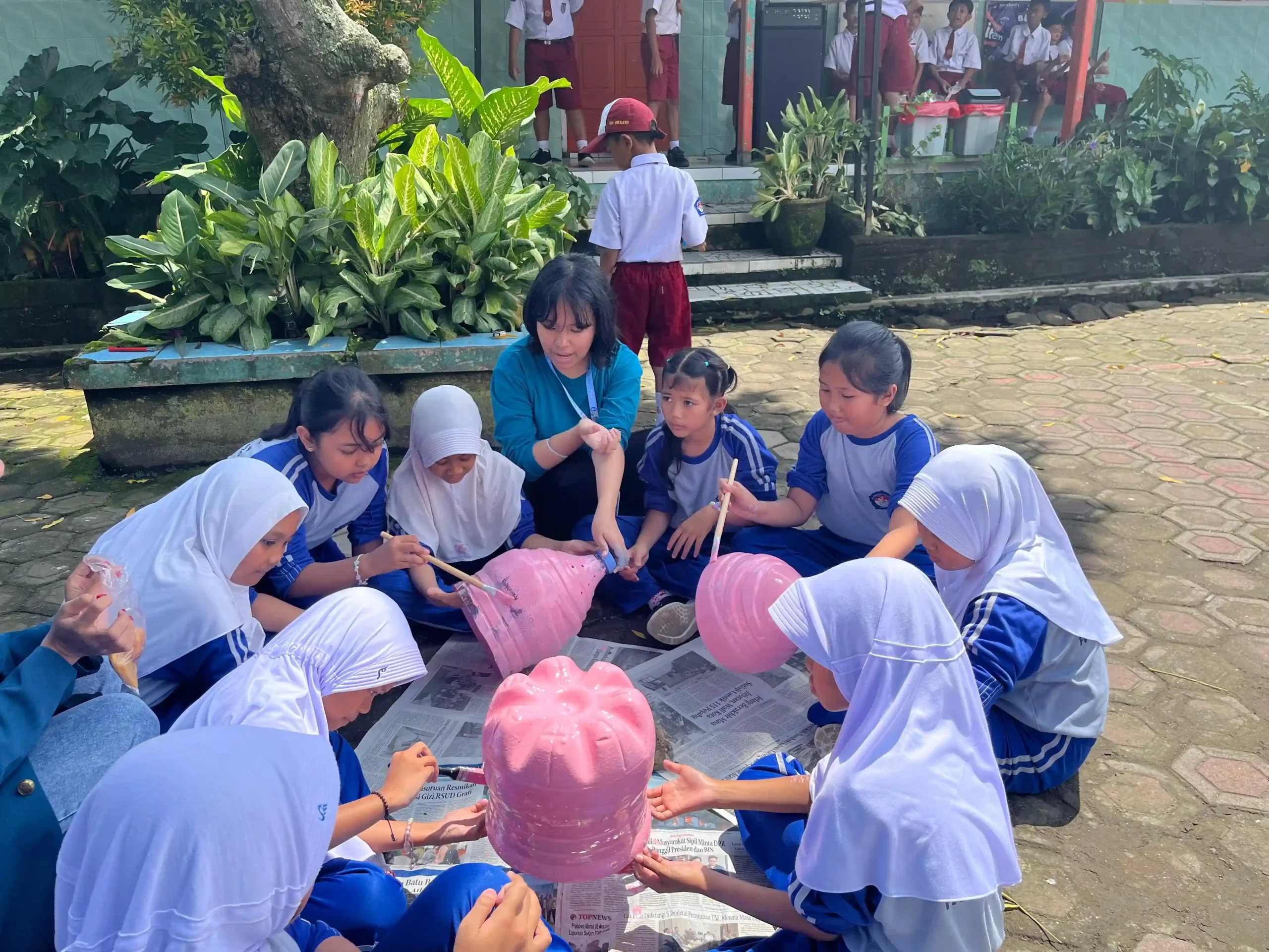 Mahasiswa BBK 7 Desa Kemiri melakukan praktik pembuatan alat komposter bersama siswa SDN 1 Kemiri