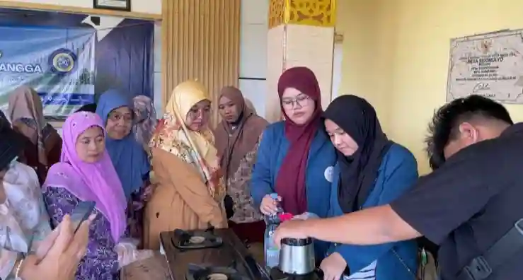 Mahasiswa BBK 7 Sidomulyo Universitas Airlangga bersama peserta sedang melakukan proses penghalusan daging ikan bandeng dan nasi untuk adonan bonggolan