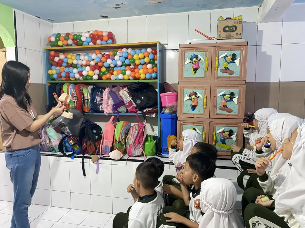 Mahasiswa KKN BBK 7 memperkenalkan cara menyikat gigi yang benar kepada anak TK Muslimat NU 2 Karangpoh, Gresik, pada Selasa (20/01/2026).