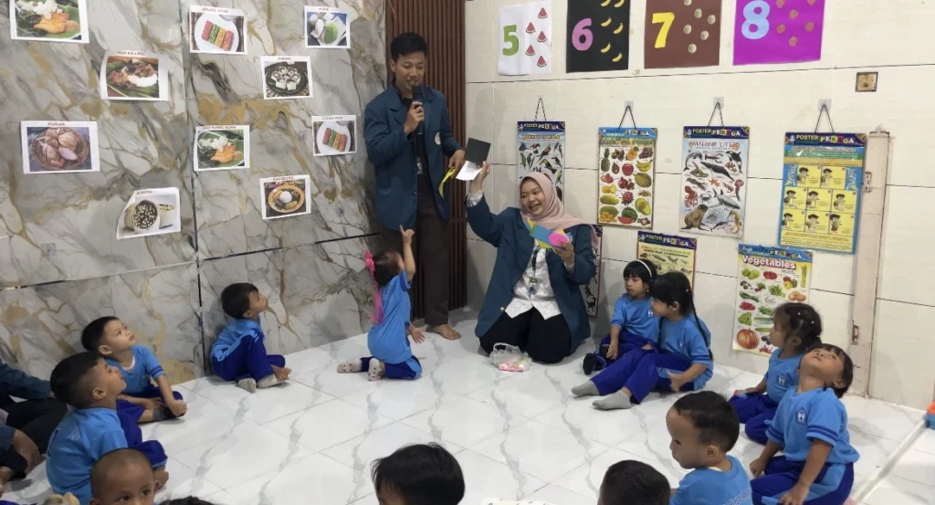 Melipat kertas origami bersama anak anak (KB) oleh mahasiswa BBK7 UNAIR Pulopancikan kepada anak-anak KB Pulopancikan