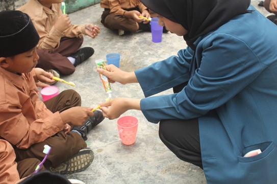 Mahasiswa KKN BBK 7 bersama siswa - siswi MI Miftakhul Huda melakukan praktek sikat gigi