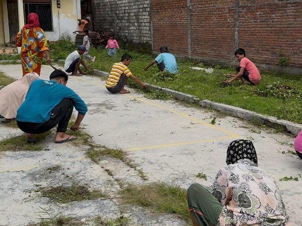 Mahasiswa BBK 7 Universitas Airlangga melaksanakan gotong royong bersama warga di Desa Sumberjo, Pucuk, Lamongan, Minggu (18/1/2026). (Foto: Dok. Tim BBK 7)