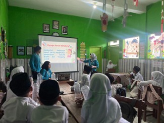Mahasiswa BBK 7 Universitas Airlangga memberikan pendampingan pembuatan celengan dari botol bekas kepada siswa SD dan MI di Desa Seloliman (Foto: Dok. Tim)