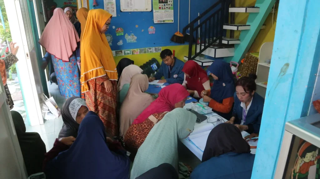 Mahasiswa BBK 7 Universitas Airlangga melaksanakan pemeriksaan kesehatan dasar kepada lansia dalam kegiatan PRIMA di Taman Posyandu Desa Kisik, Kecamatan Bungah, Kabupaten Gresik, Senin (19/1/2025). (Foto: Dok. Tim BBK 7)