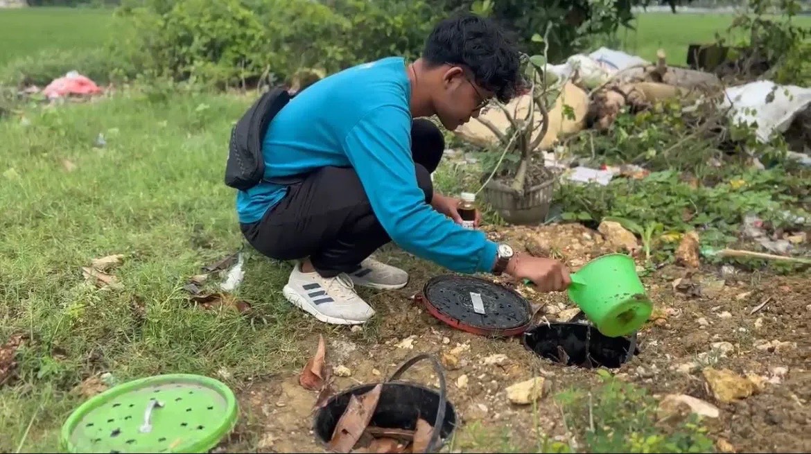 Penyiraman larutan EM4 dan tetes tebu ke lubang biopori di TPS Anugrah Bersama, Desa Datinawong, pada Jumat (24/1/2026), untuk mempercepat proses pengomposan sampah organik. (Dok. Istimewa)