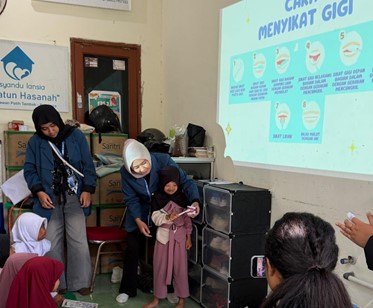 Mahasiswa BBK-7 UNAIR saat pelaksanaan demonstrasi cara menyikat gigi dalam program kerja “Senyum Sehat, Anak Sekolah Rakyat” di Sekolah Rakyat Kejawan, Kelurahan Kejawan Putih Tambak, Minggu (25/1/2026). (Foto: Dok. Tim)