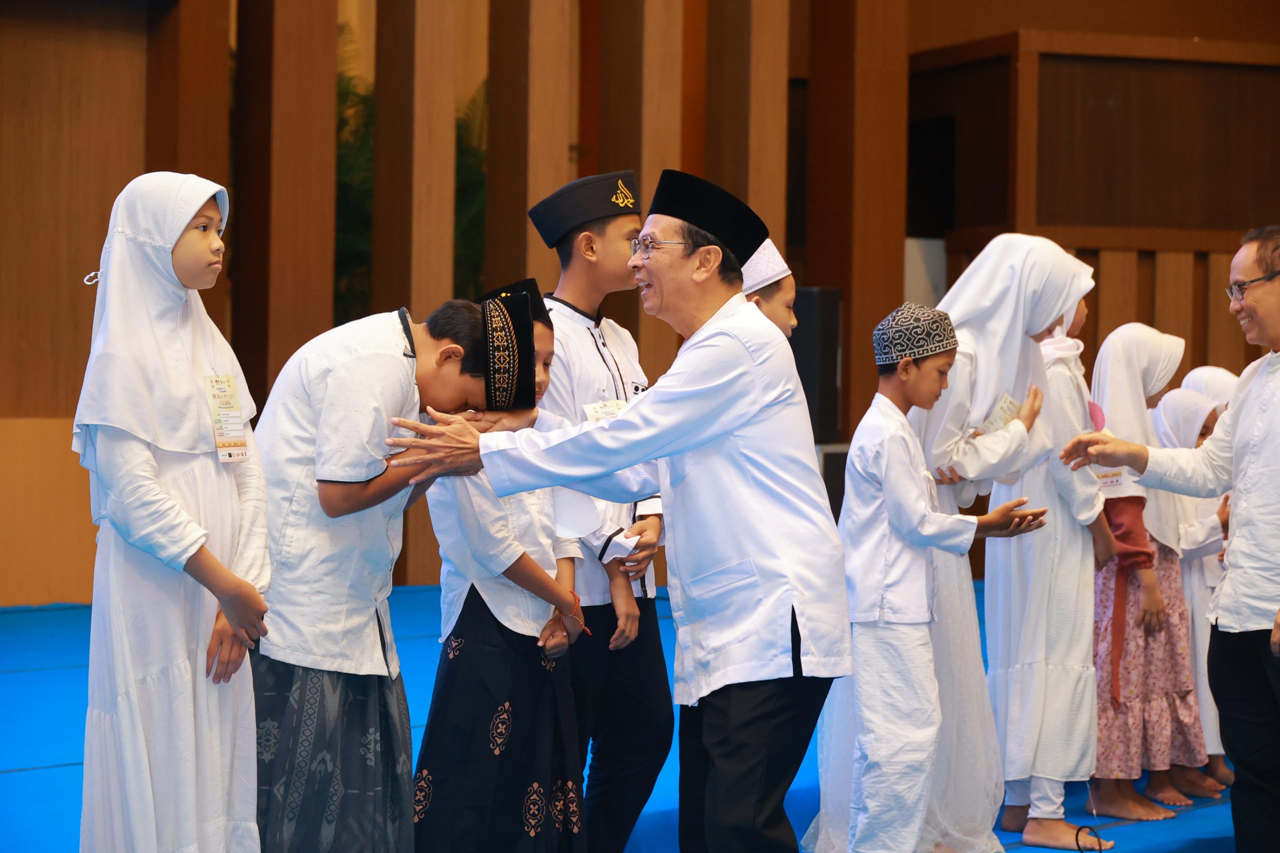 Rektor UNAIR, Prof Dr Muhammad Madyan, SE MSi MFin, saat menyapa perwakilan dari anak yatim pada acara buka puasa bersama 1000 anak yatim di Airlangga Convention Center (ACC) pada Jumat (06/03/2026). (Foto: PHMP UNAIR)