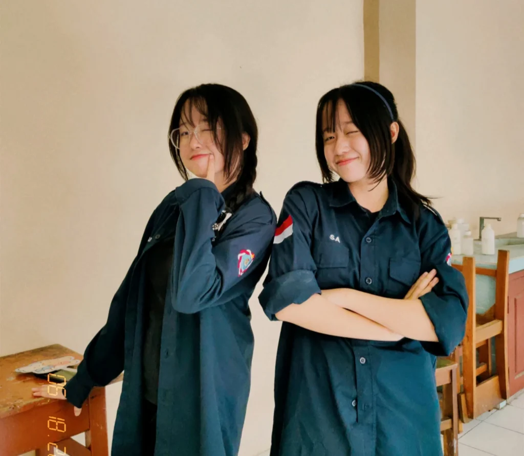 Twin sisters Carissa Elvina Angela (right) and Callista Elysia Angela (left), who were admitted to Universitas Airlangga (UNAIR) through the National Selection Based on Achievement (SNBP), celebrate their acceptance (Photo: By courtesy).