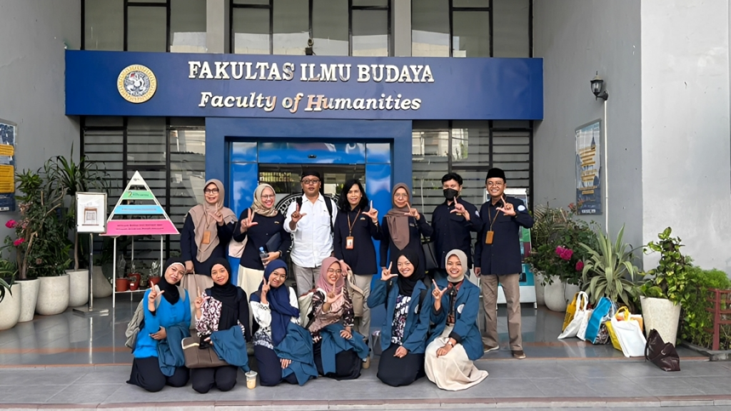 Tim Pengmas Dosen dan Mahasiswa Sasindo FIB UNAIR saat sesi foto bersama di depan lobi gedung FIB UNAIR (Sumber: Dokumentasi Tim).