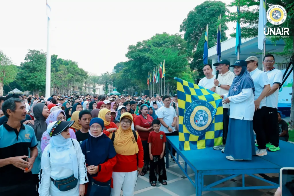 Rektor memgang bendera start didampingi Dekan FKG, Dekan FTMM dan pimpinan UNAIR lainnya memberangkatkan peserta jalan sehat pada Minggu (24/05/2026) di depan Gedung Manajemen UNAIR Kampus MERR-C Mulyorejo