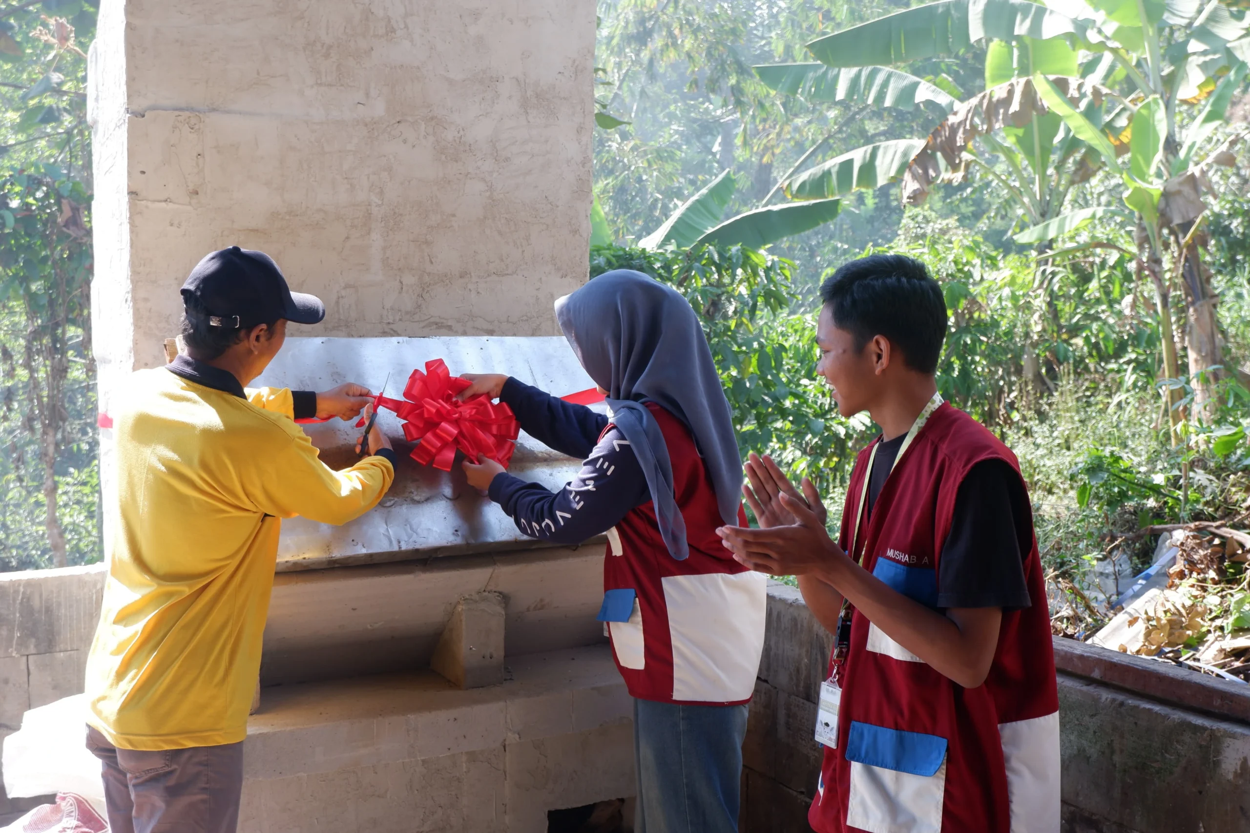Dari kiri, Pak Agus selaku Ketua BUMDes bersama Naicilla dan Mushab Selaku Penanggung Jawab Proyek Meresmikan Rocket Stove Desa Gerbo pada (20/07) di TPS Desa Gerbo (Sumber: Panitia Deputra 9.0).