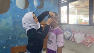 Dekan FKH UNAIR, Prof Dr Lilik Maslachah drh MKes saat sesi pengukuran lingkar kepala pada siswa di SDN Banjarjo II Bojonegoro, Senin (6/7/2026). (Foto: Erika Eight Novanty)