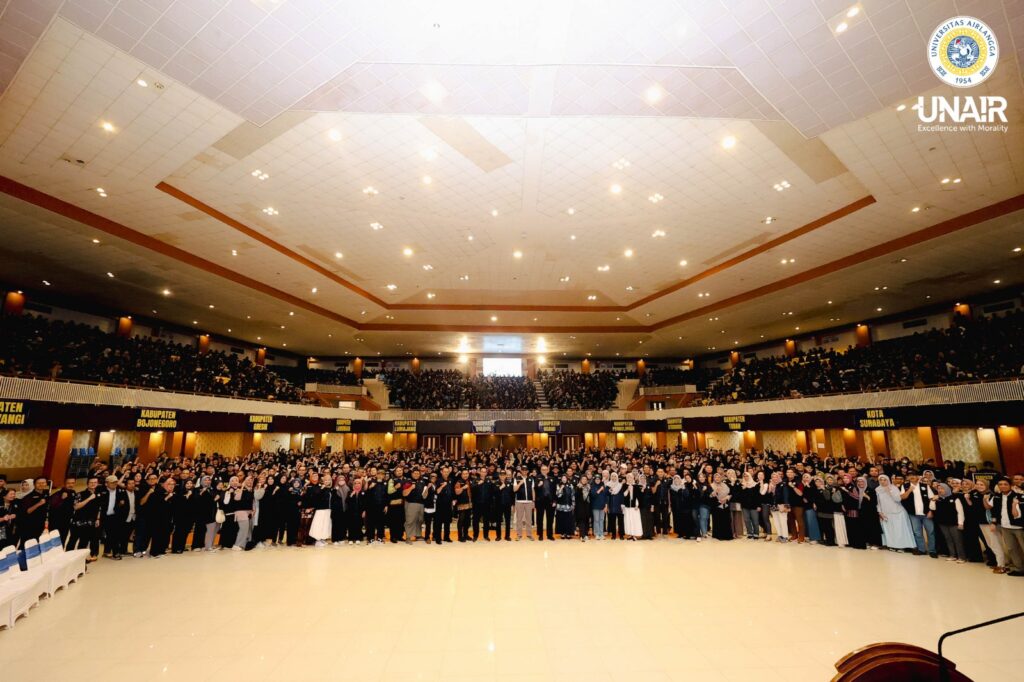 Sesi foto bersama jajaran pimpinan UNAIR, Dosen Pendampung dan para mahasiswa Belajar Bersama Komunitas (BBK) ke-8 pada Upacara Pelepasan Mahasiswa BBK ke-8 UNAIR di Airlangga Convention Center (ACC), Minggu (12/7/2026). (Foto: PHMP UNAIR)