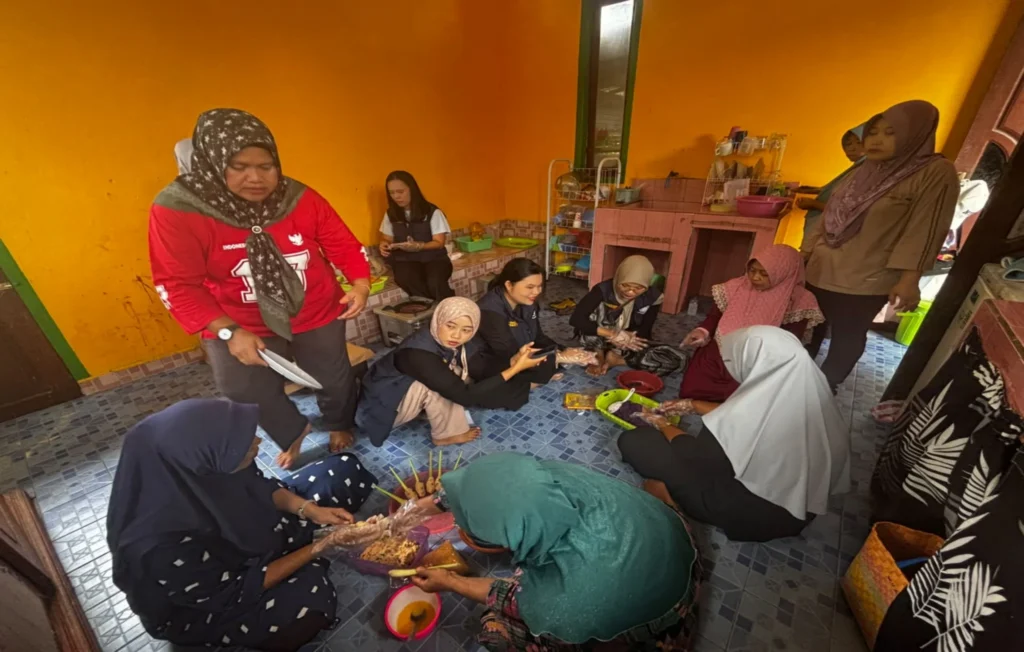 Tim 3 Ekspedisi Patriot UNAIR bersama para kader Kampung Aimasi saat mempraktikkan secara langsung tahapan pengolahan resep kudapan sehat tanpa proses penggorengan. (Foto: Istimewa)