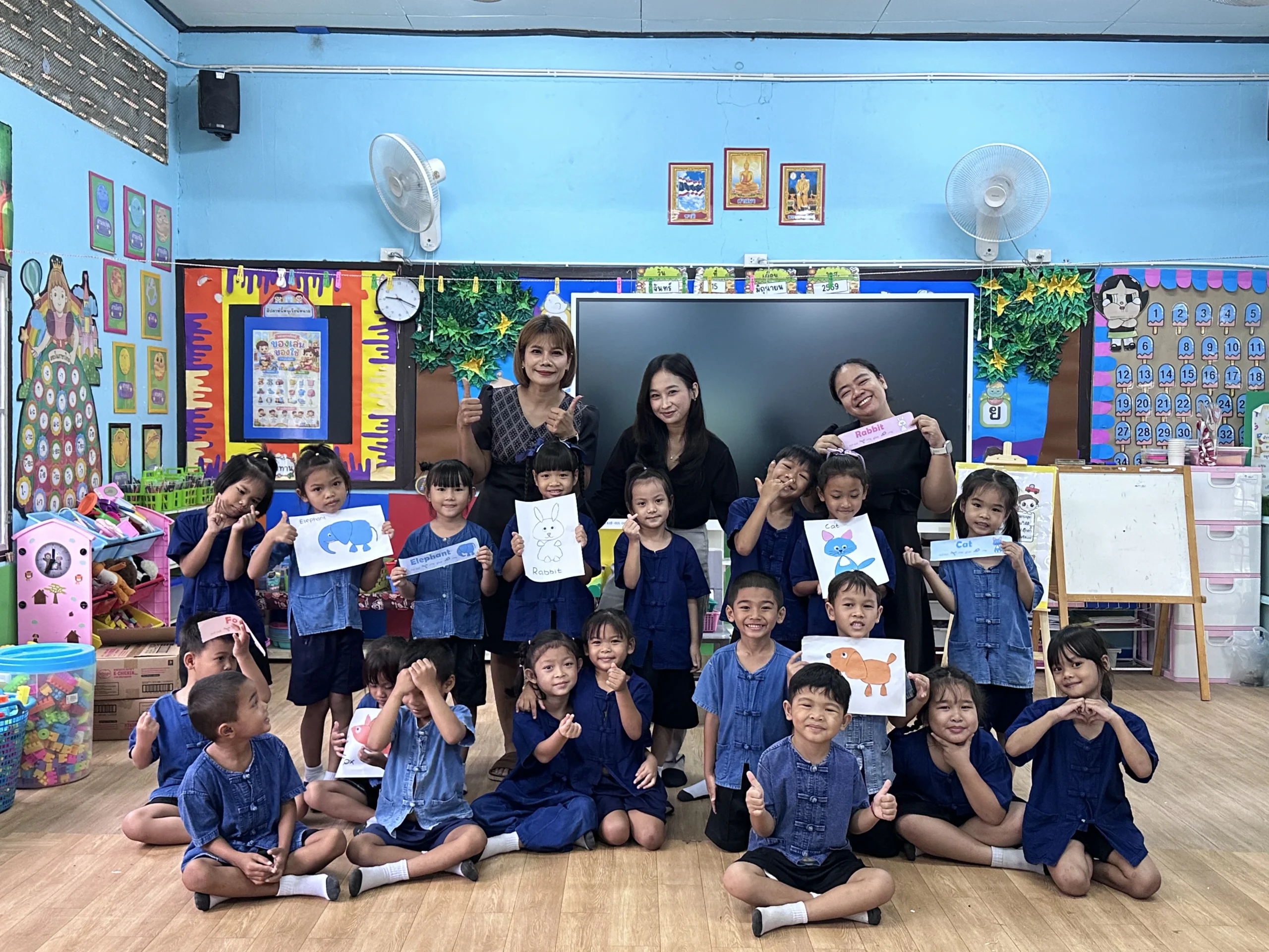 Pramesti Dirgantara berfoto bersama guru pendamping dan murid-murid di sekolah penempatannya di Thailand, usai kegiatan belajar kosakata nama-nama hewan dalam bahasa Inggris.(Foto: Dokumentasi pribadi Pramesti Dirgantara)