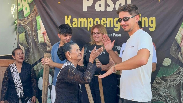 Peserta Hosting International Exchange memainkan alat musik tradisional dan menari bersama masyarakat Osing di Desa Wisata Osing Kemiren, Banyuwangi, Minggu (13/9/2026). Kegiatan tersebut menjadi bagian dari pengenalan budaya Osing melalui pengalaman langsung bersama masyarakat setempat. (Foto: Zahwa Yasmina)