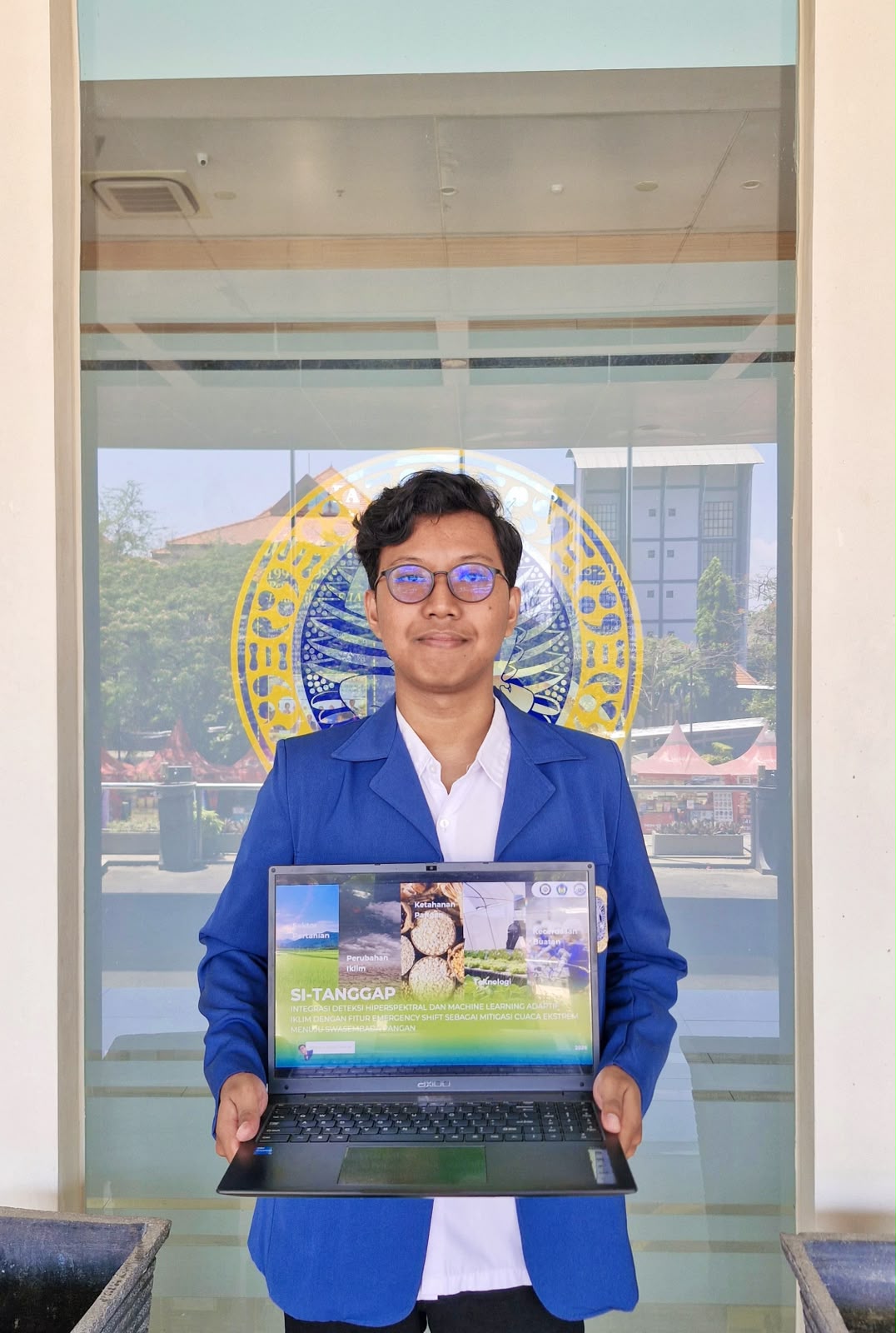 Mahasiswa S1 Kimia FST UNAIR Abraham Alexs Tanu Wijaya menunjukkan karya esainya berjudul “SI-TANGGAP” yang meraih Juara I FISION 2026. (Foto: Dokumentasi Pribadi)