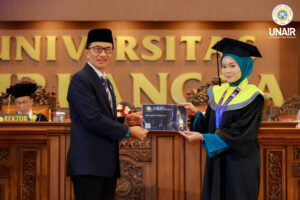 FOTO PP IKA UNAIR, Dr M Syaiful Aris SH MH LLM saat memberikan kartu IKA kepada salah satu wisudawan terbaik Afra Bahita Fridajaya. (Foto: Humas UNAIR)