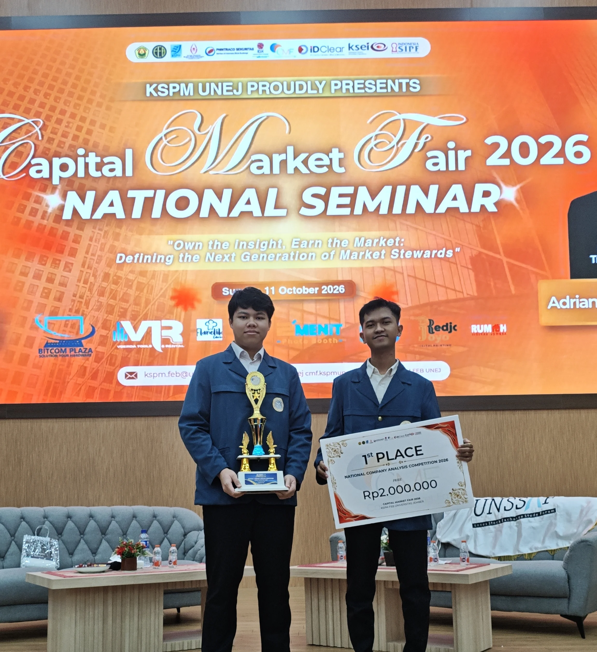 Tim The Chosen One FEB UNAIR, Nurul Alfiandy dan Adi Nugroho, saat menerima penghargaan Juara Satu pada ajang National Company Analysis Competition (COMPAS) 2026 di Universitas Jember, Sabtu (10/10/2026). (Foto: Istimewa)