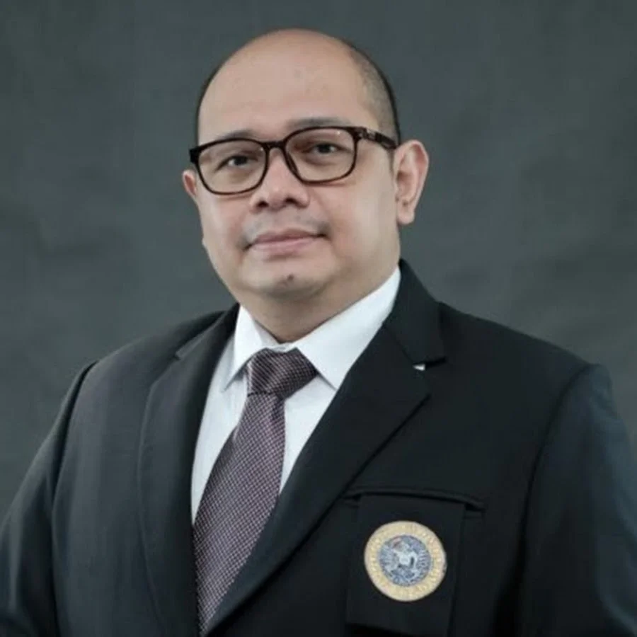Seorang laki-laki mengenakan jas dengan logo Universitas Airlangga dan mengenakan kacamata. Ia adalah Dr Wisudanto, dosen Departemen Manajemen FEB UNAIR