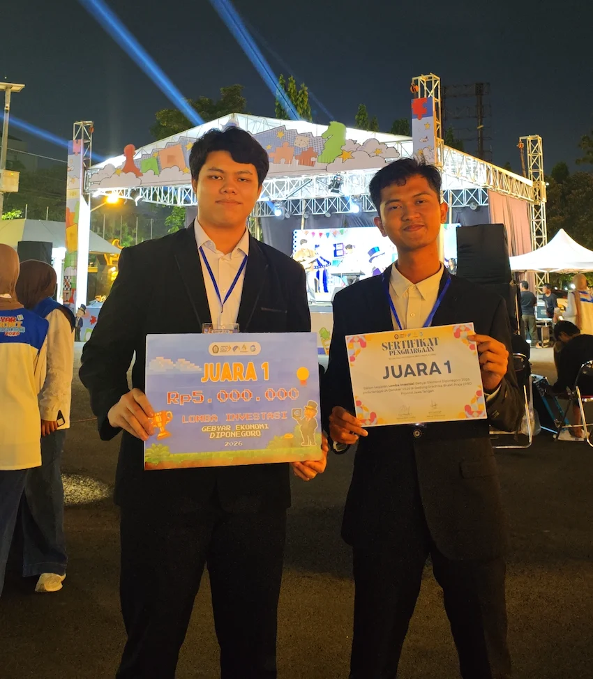 Dua mahasiswa FEB UNAIR, Nurul Alfiandy (kiri) dan Adi Nugroho (kanan), menunjukkan simbolis hadiah dan sertifikat Juara 1 Lomba Investasi Gebyar Ekonomi Diponegoro (GED) 2026 usai babak final di Semarang, Sabtu (24/10/2026). (Foto: Dok. Istimewa)