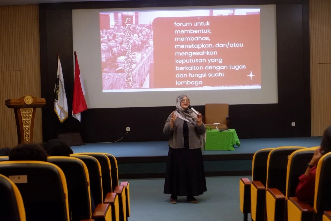 Diinaar Rahmatina SA, Ketua Komisi Legislasi DLM UNAIR, memaparkan materi tata tertib dan mekanisme persidangan dalam SELEGTIF I di Maleo Hall, Gedung Medang, Sabtu (17/10/2026) (Foto: Team Media Sekolah Legislatif)