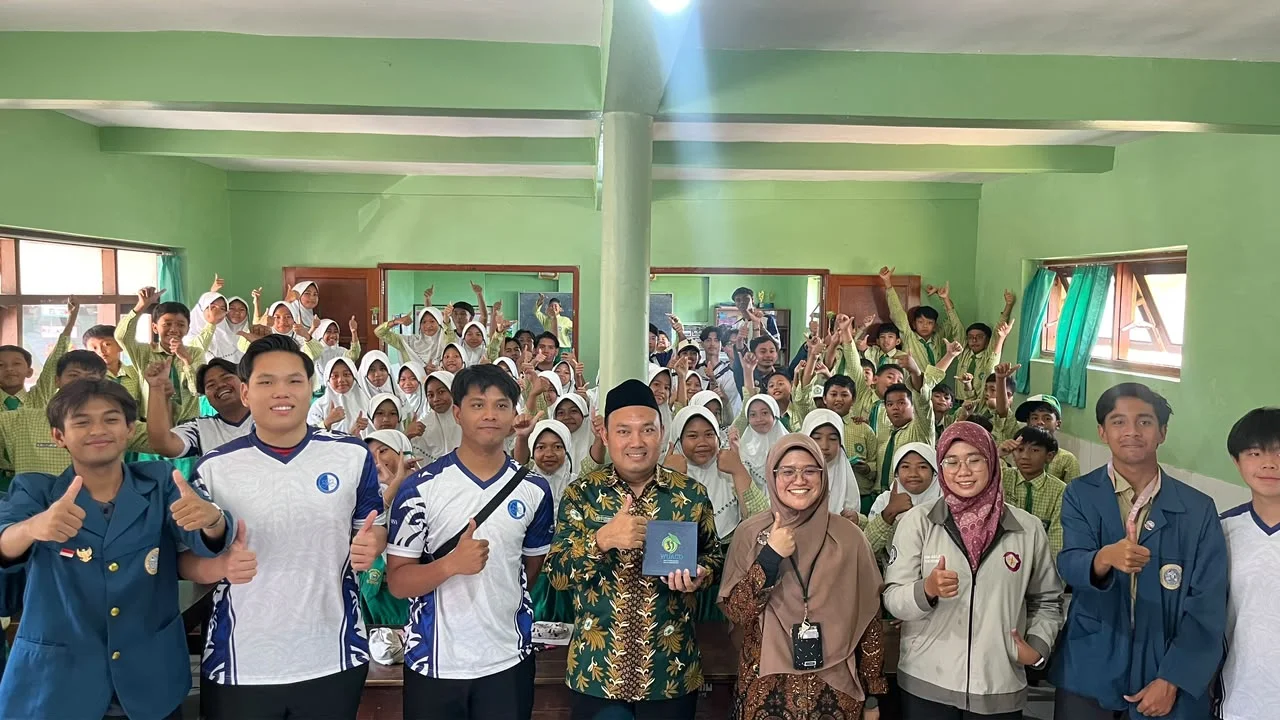 Delegasi mahasiswa UNAIR dan UTM bersama para siswa kelas enam MI Dwi Dasa Warsa mengabadikan momen kebersamaan seusai sesi pengajaran edukatif anti-perundungan dan pelestarian lingkungan pada Kamis (15/10/2026). (Foto: Istimewa)